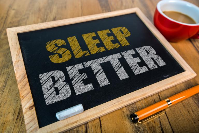Small chalkboard with the message Sleep Better written in chalk on it.